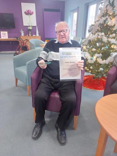 A picture of Peter Morley, Inspirational Gardener of the Year winner, holding his certificate and trophy